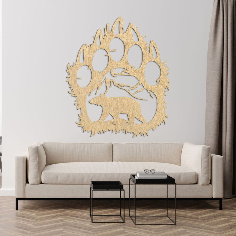 Egy nagy, négykarmos medvemancs faragott alakja, valamint egy hegyekkel és egy medvével díszített tájkép részlete.