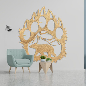 Egy medvelábnyom fából készült képe, amelynek belsejében egy hegyek alatt sétáló medve sziluettje van faragva.