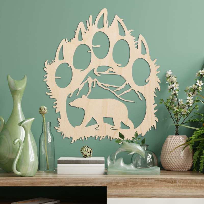 Egy medveösvény kontrasztos sziluettje, amelyen belül egy hegylánc és egy előre sétáló medve alakja látható.