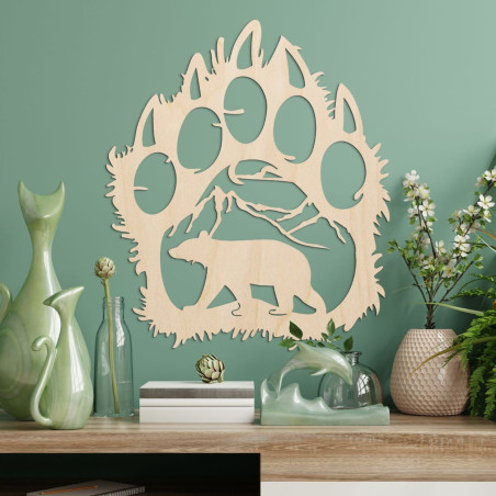 Egy medveösvény kontrasztos sziluettje, amelyen belül egy hegylánc és egy előre sétáló medve alakja látható.