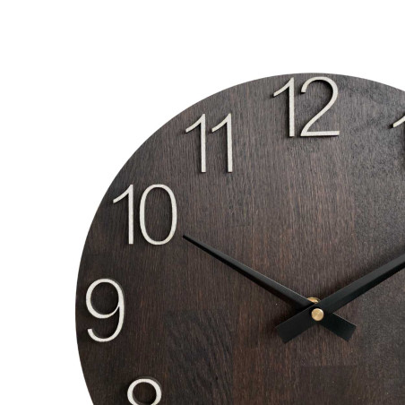 Fából készült falióra faragott számokkal és fém mutatókkal.