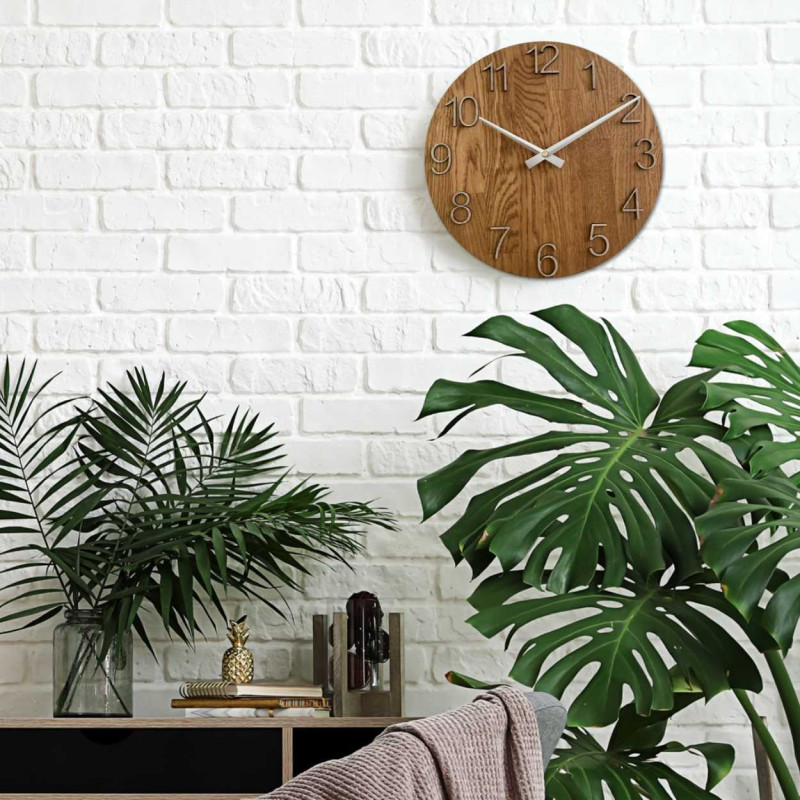 Kerek óra dekoratív kivágással a közepén és finom fa mintával.