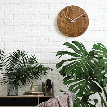 Kerek óra dekoratív kivágással a közepén és finom fa mintával.