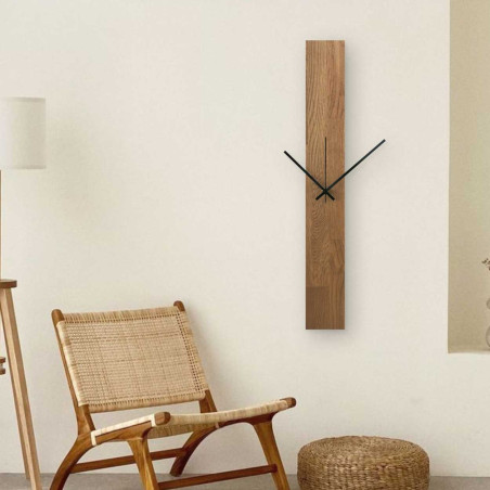 Függőleges faóra kombinált fekete és ezüst mutatókkal, számok nélkül.